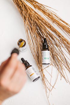 Natural skincare product with dropper bottles and dried branches on a white background.