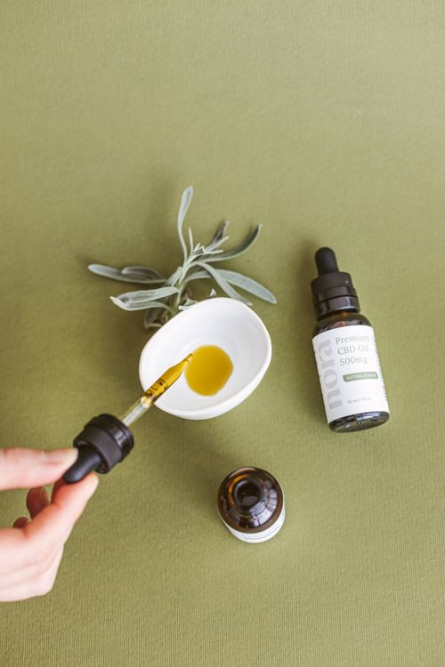 Free Close-up of CBD oil being poured into a bowl with plants for wellness. Stock Photo