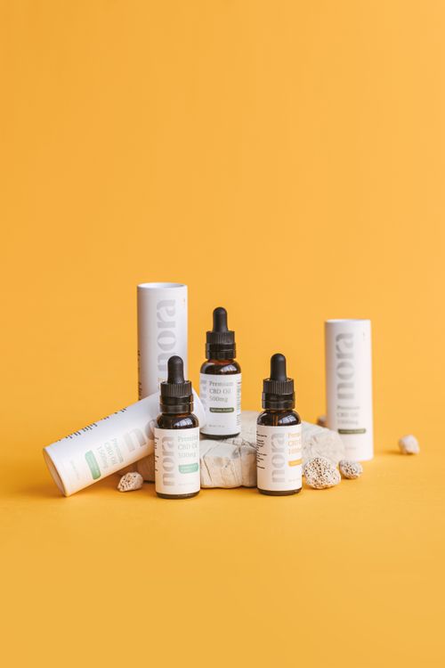 Free Product photography of CBD oil bottles and packaging against a yellow background. Stock Photo