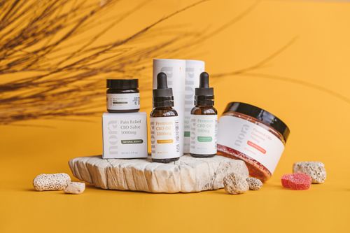 Free Premium CBD products featured on a vibrant yellow background with natural elements. Stock Photo