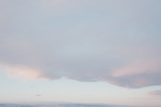 A gentle and dreamy cloudy sky scene with soft pastel hues at dawn.