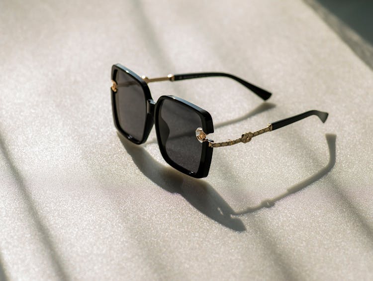 A Black Framed Chanel Sunglasses On White Textile