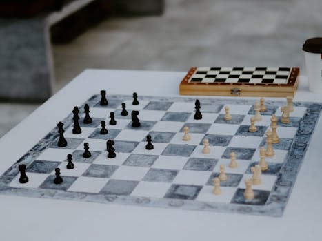 Outdoor chess game setup showcasing strategic play with chess pieces on board.