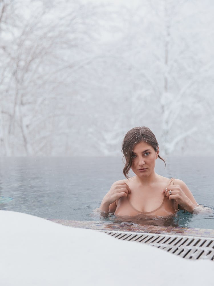 Woman In The Outdoor Pool Among Snow Covered Trees