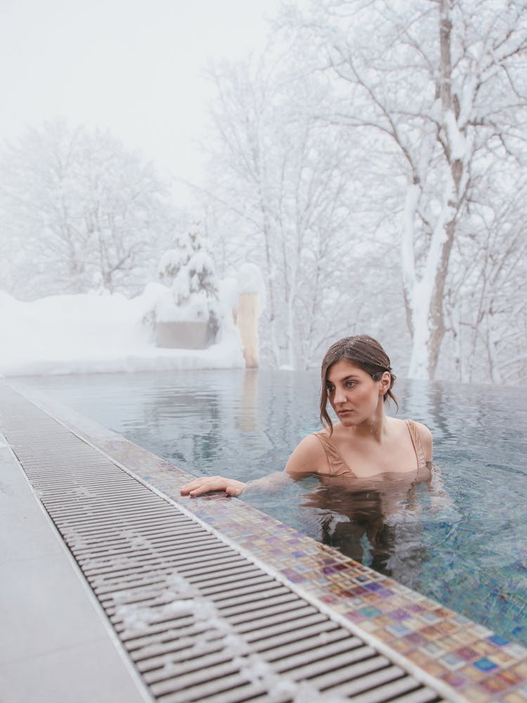 A Woman Swimming In A Pool During Winter