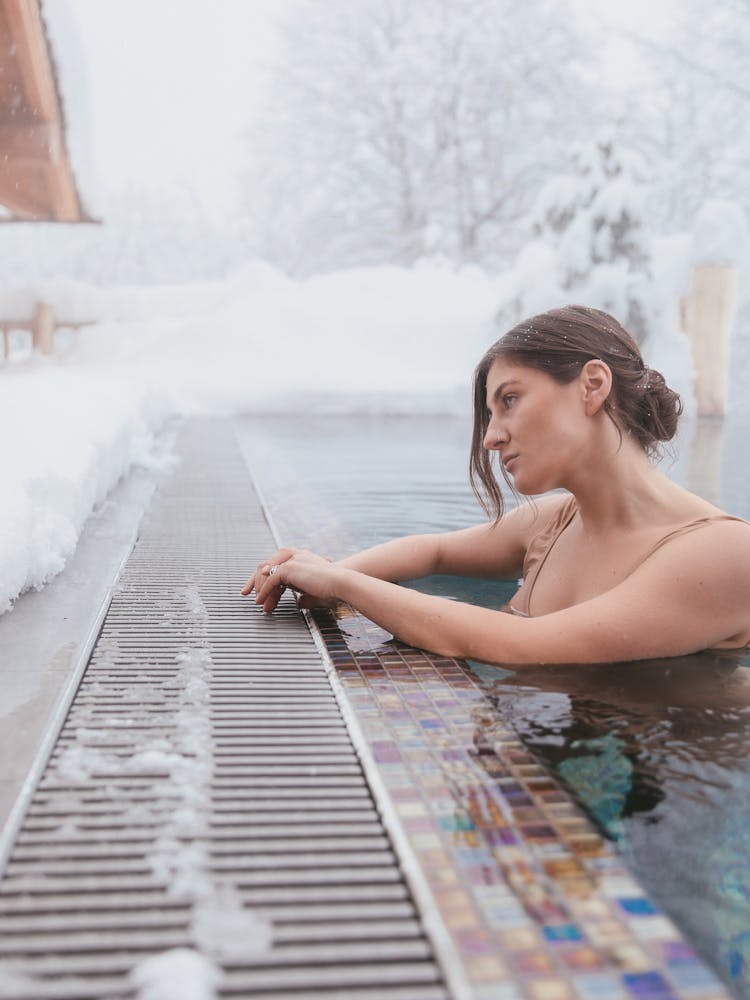 A Woman Swimming In A Pool During Winter