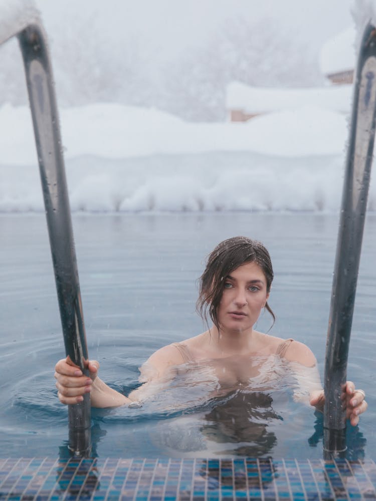 A Woman Swimming In A Pool During Winter