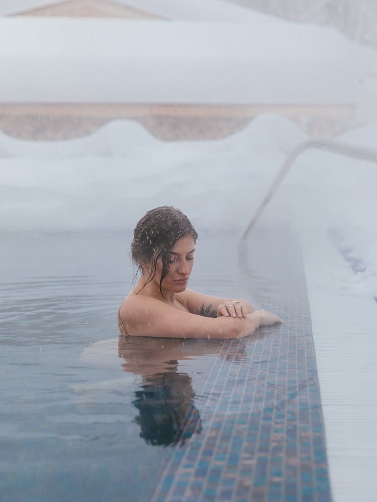 A Woman Swimming In A Pool During Winter