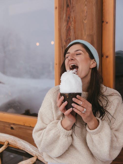 Woman in Brown Sweater Eating Snowflakes