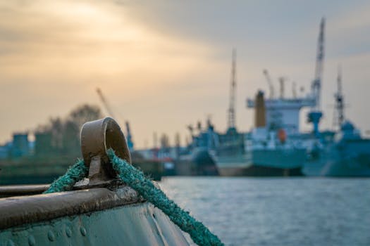 Close-up of dock with ships in industrial harbor at sunset, highlighting maritime industry.