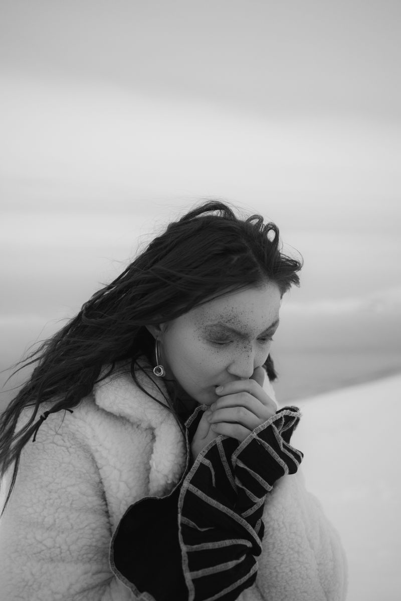 Grayscale portrait of woman in fur coat in snow