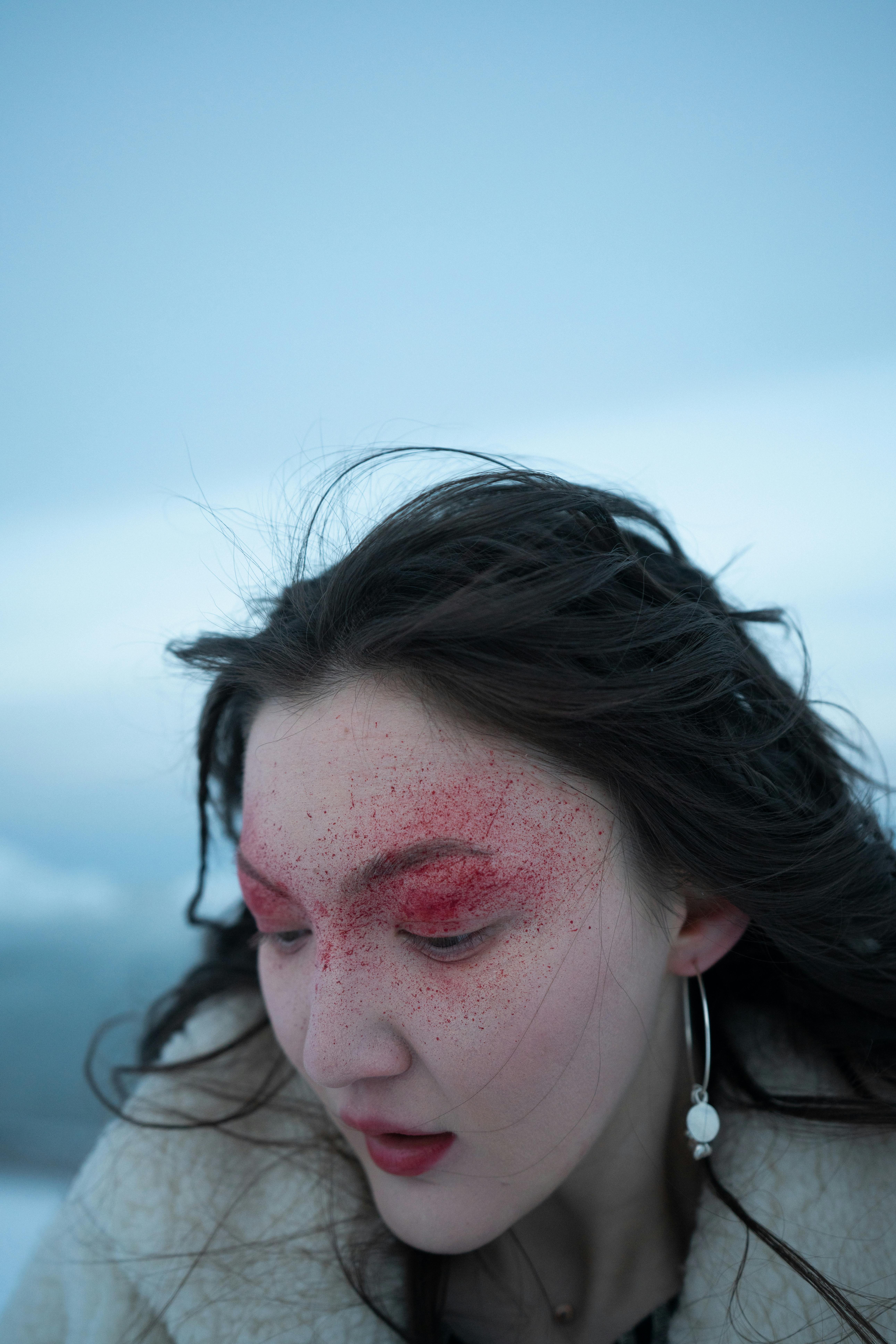Editorial beauty portrait with concentrated red around the cheekbones, more romantic than neutral