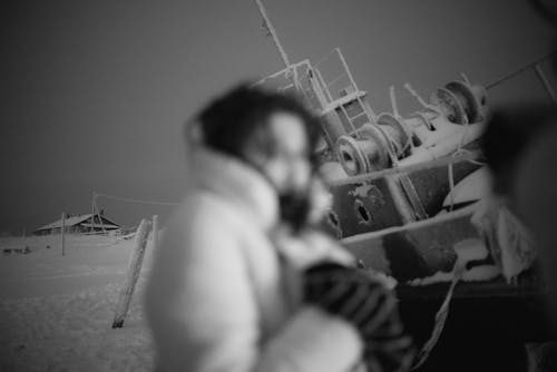 A Person Standing Near a Wrecked Boat