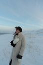A Woman Wearing Winter Clothing While Standing on the Snow Covered Ground