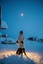 Woman in White Coat Standing on Snow Covered Ground