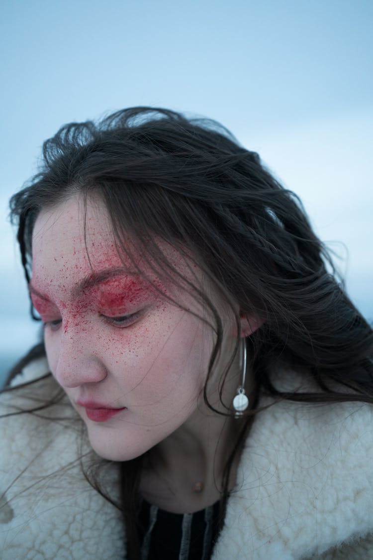 Woman With Red  Powder On Her Face Looking Down