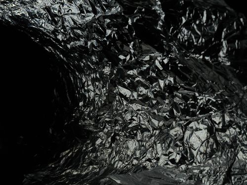 Free Close-up of crumpled metallic foil creating an abstract and artistic texture. Stock Photo