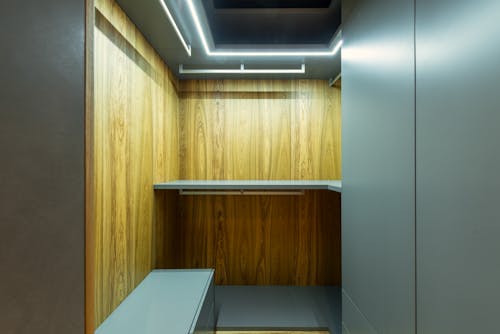 Modern wardrobe with racks and shiny lights in house