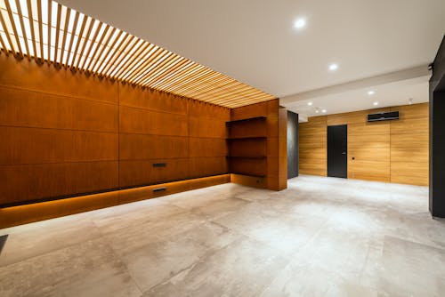 Modern corridor interior with entrance door and air conditioning against wooden shelves above floor in house