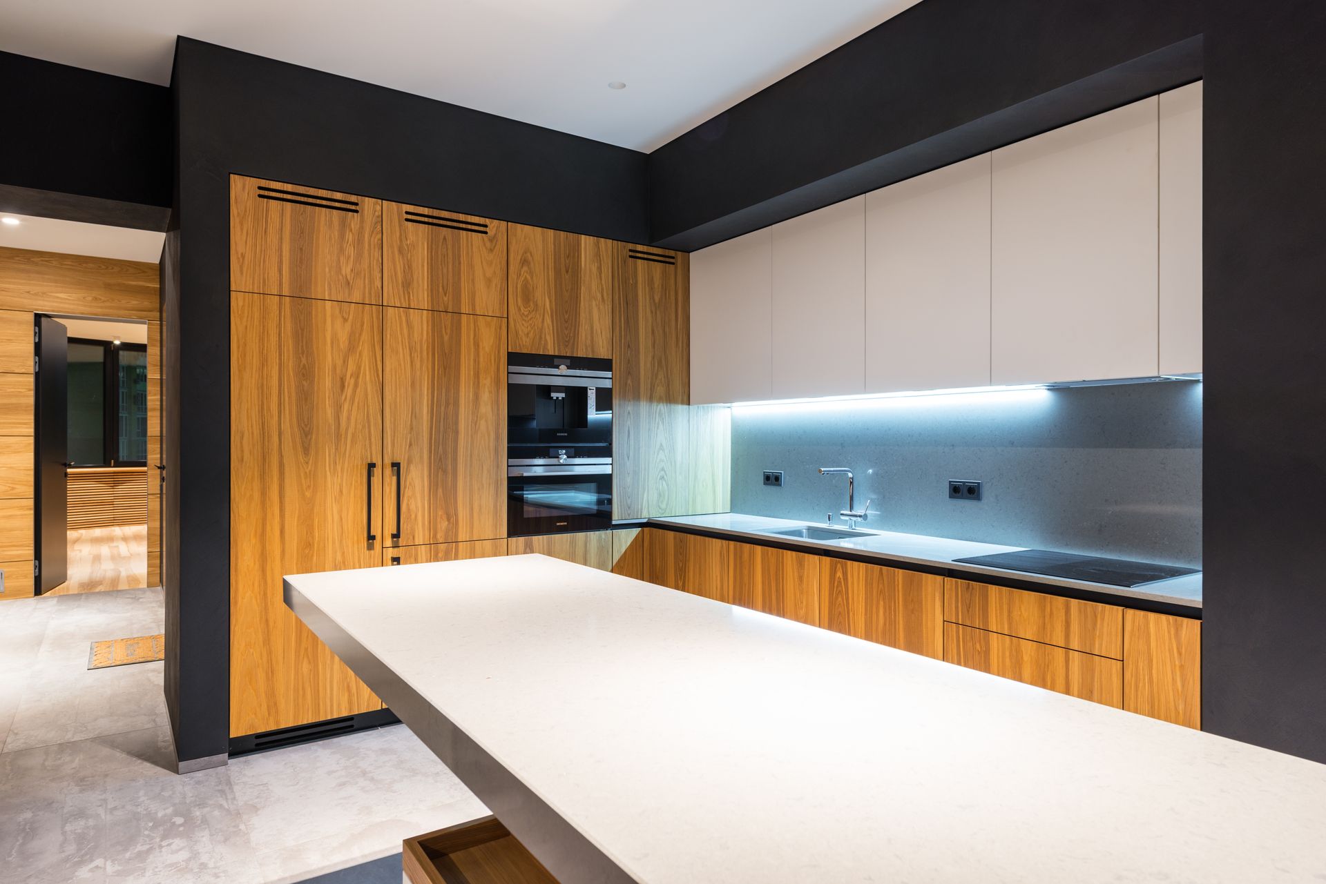 Creative design of kitchen with wooden cabinets and built in electric appliances against table in light house