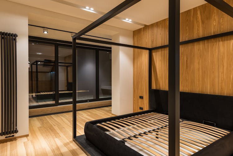 Bed Frame Reflecting In Window In Modern House