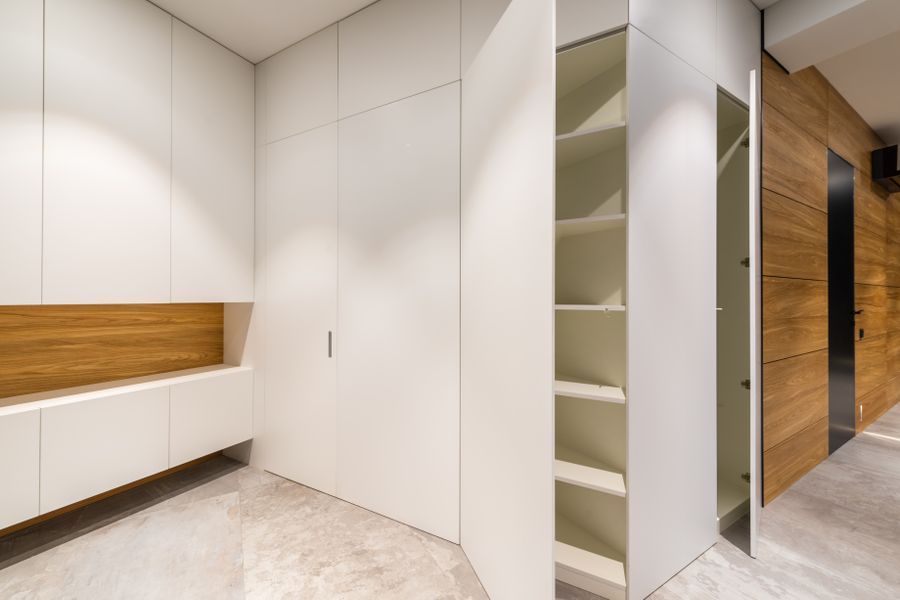 Contemporary empty room with white closet and shelves above gray floor in light house