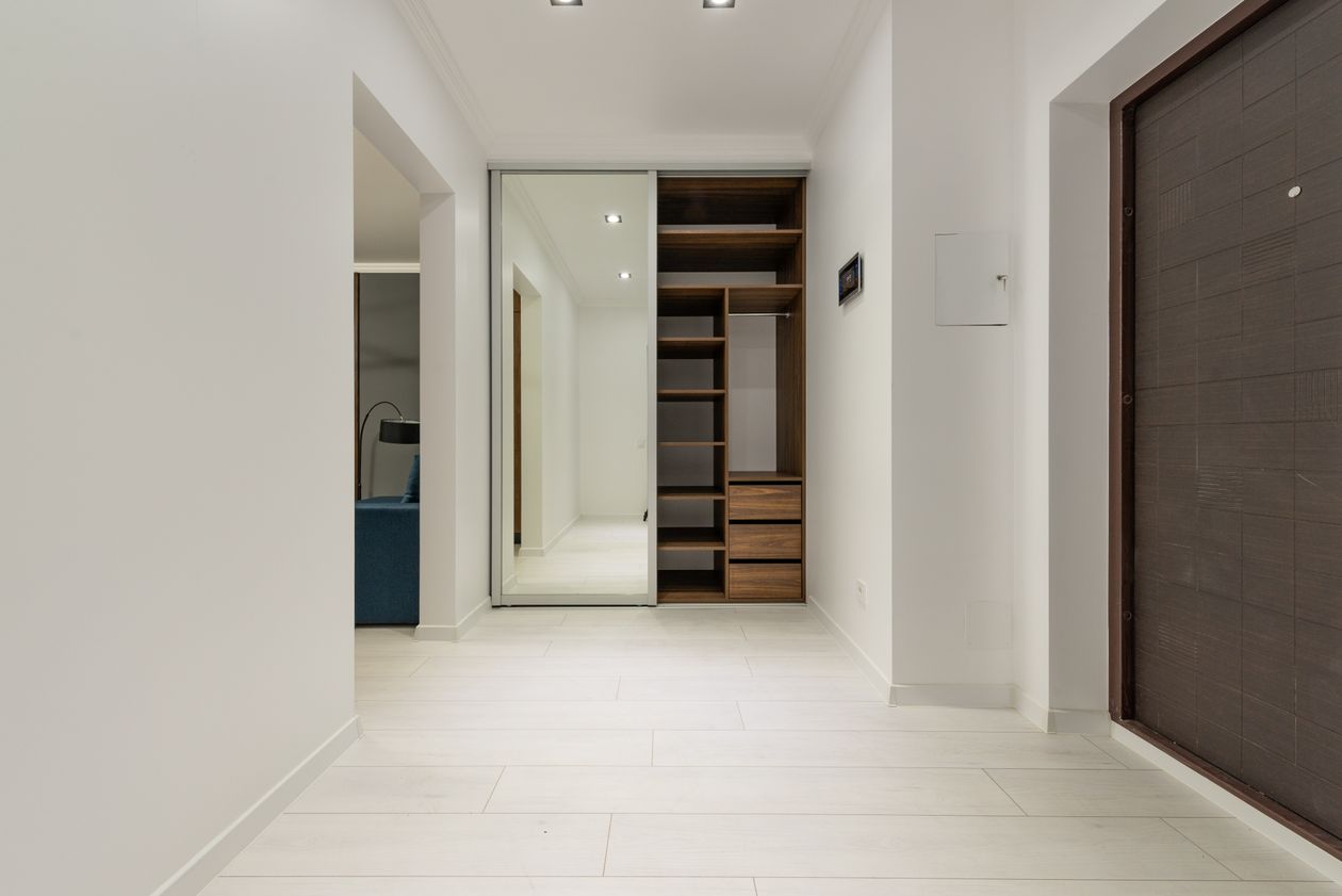 Hallway with a mirrored sliding-door storage unit and wooden shelves