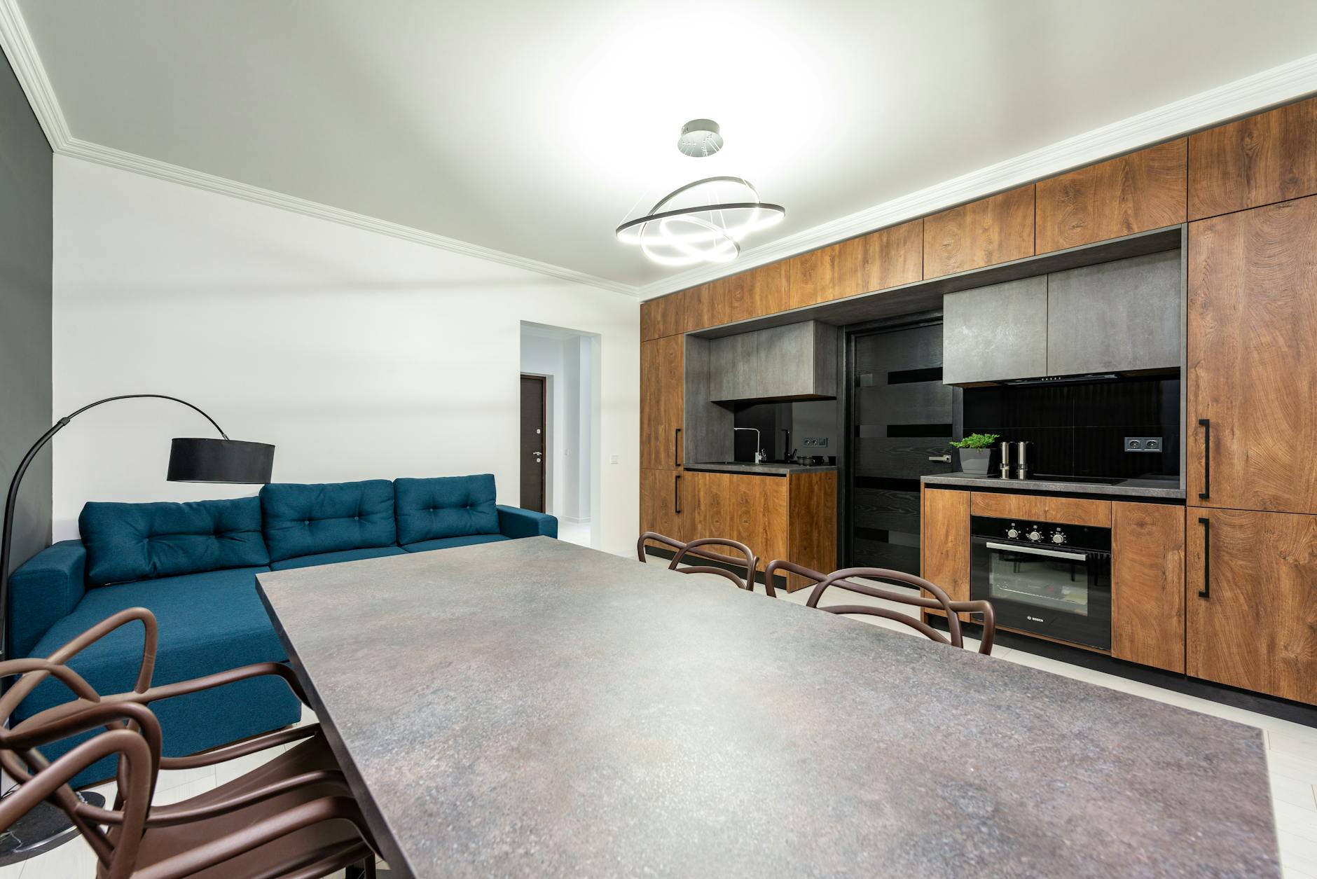 Spacious modern kitchen and dining area with stylish furnishing and elegant lighting.