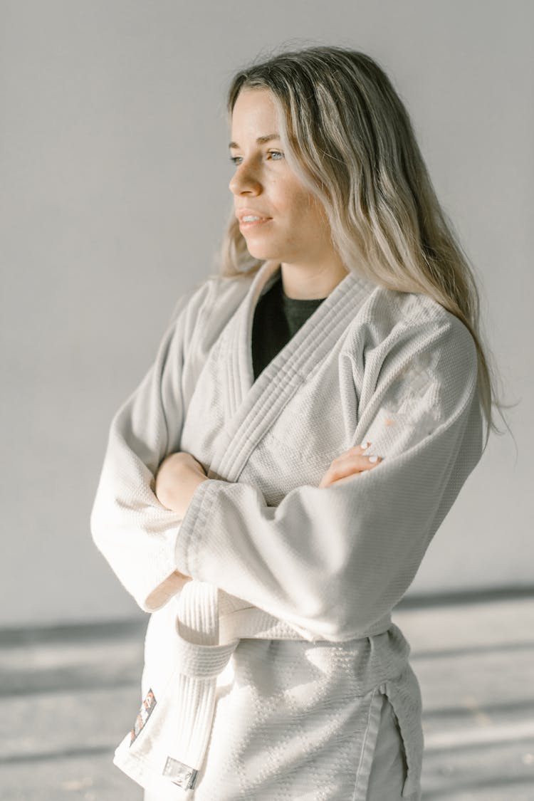 A Woman In Taekwondo Uniform With Her Arms Crossed