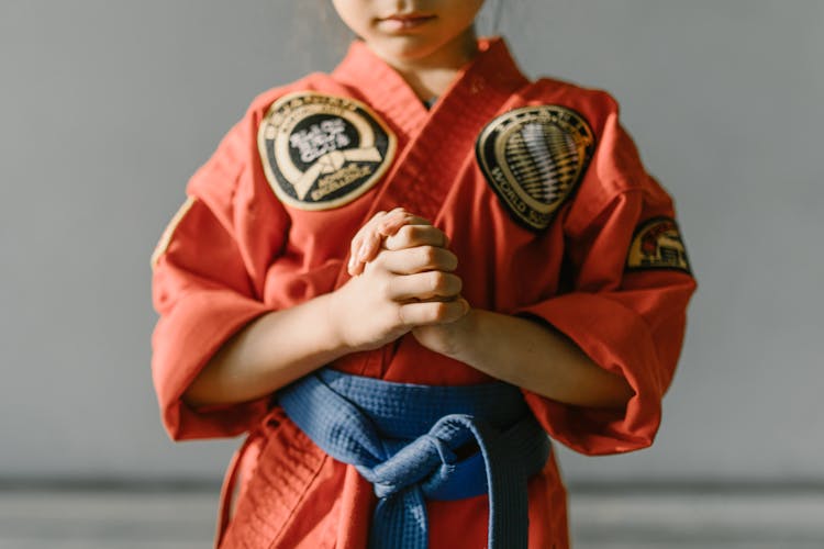 Close-Up Shot Of A Girl Wearing Red Dobok And Blue Belt
