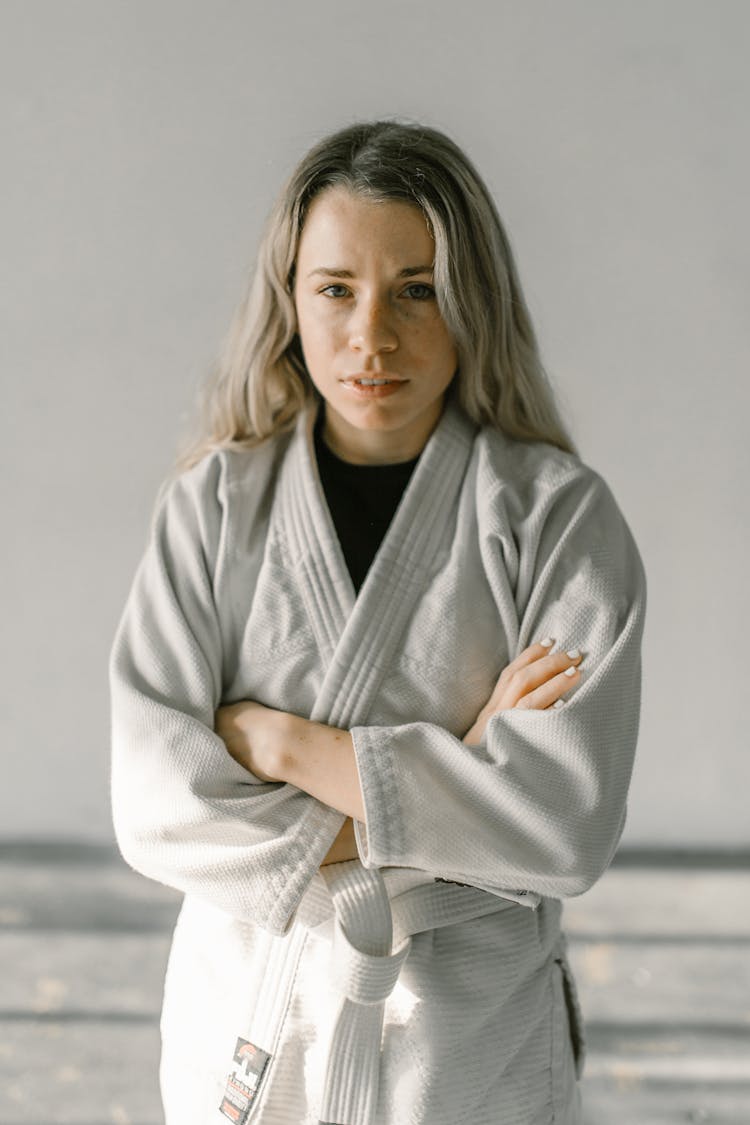 A Woman In Taekwondo Uniform With Her Arms Crossed