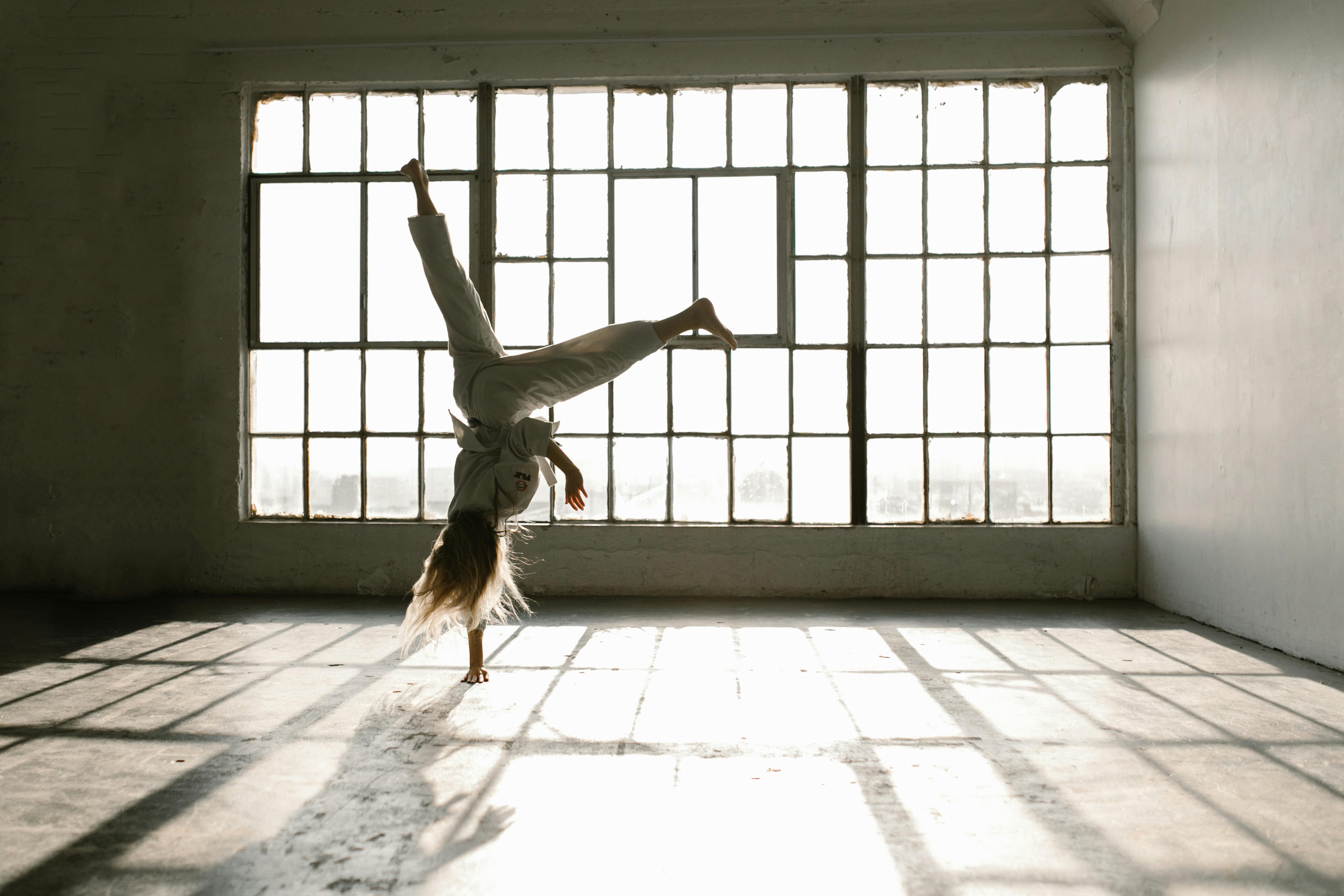 a person performing flip maneuver over the concrete floor