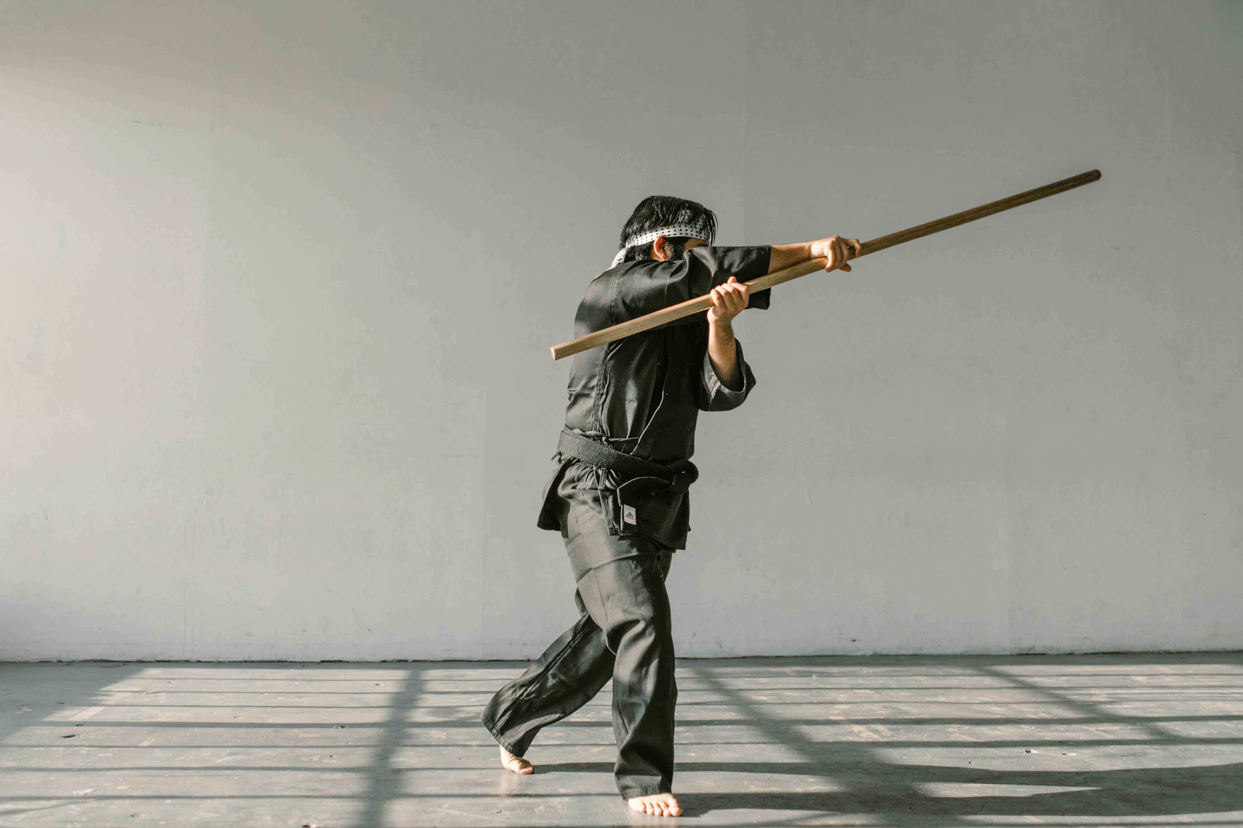 man in black and white suit holding a brown wooden stick