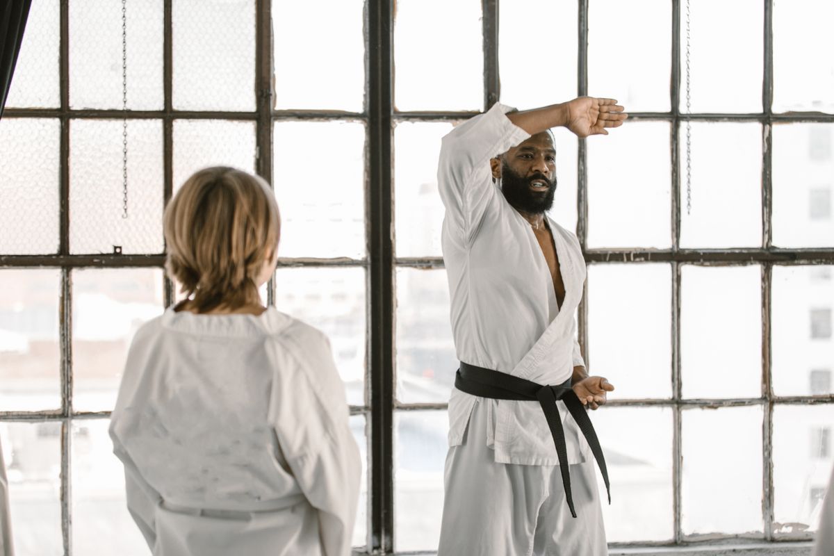 Taekwondo practitioners practicing synchronized technical forms in dojang