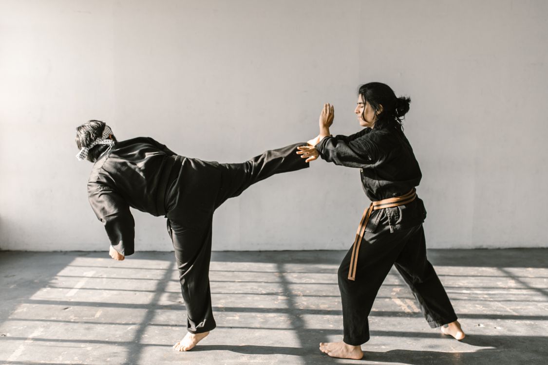 Man Defrending Long Haired Man Defending Himself From the Person's Kick · Free Stock Photo