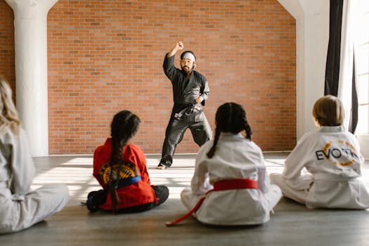 Instructor demonstrating martial arts to children in a dojo setting, highlighting focus and learning.