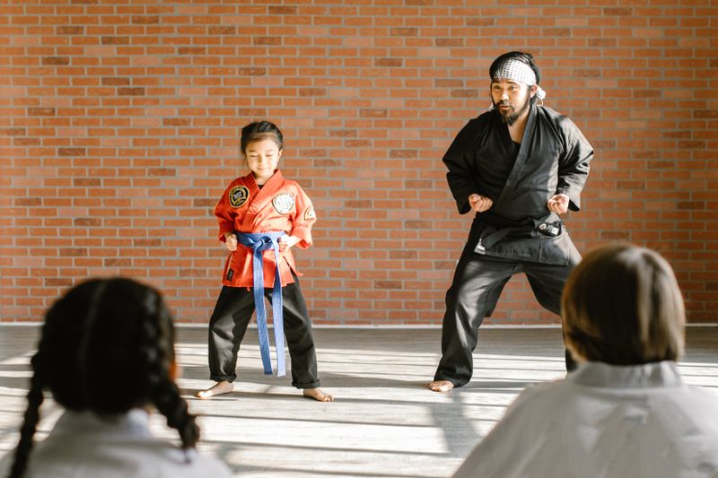 Judo instructor training with a young student in the dojo