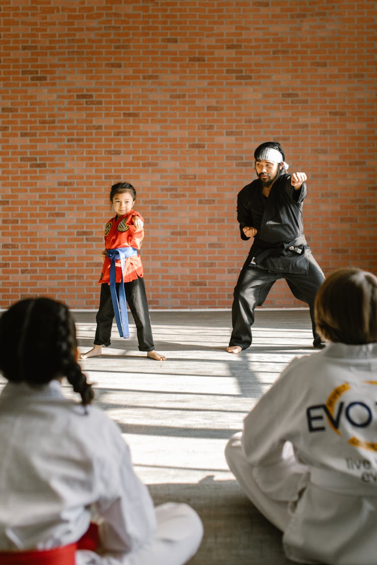 Man Teaching The Girl How To Do The High Punch 