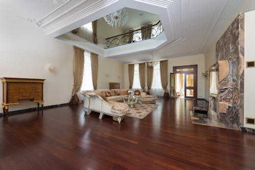 Free Creative design of spacious room interior with sofa and table on carpet under chandelier in light house with wooden floor Stock Photo