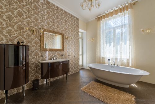 Free Interior of spacious bathroom with soft rug and beige walls with patterns and window decorated with curtains Stock Photo
