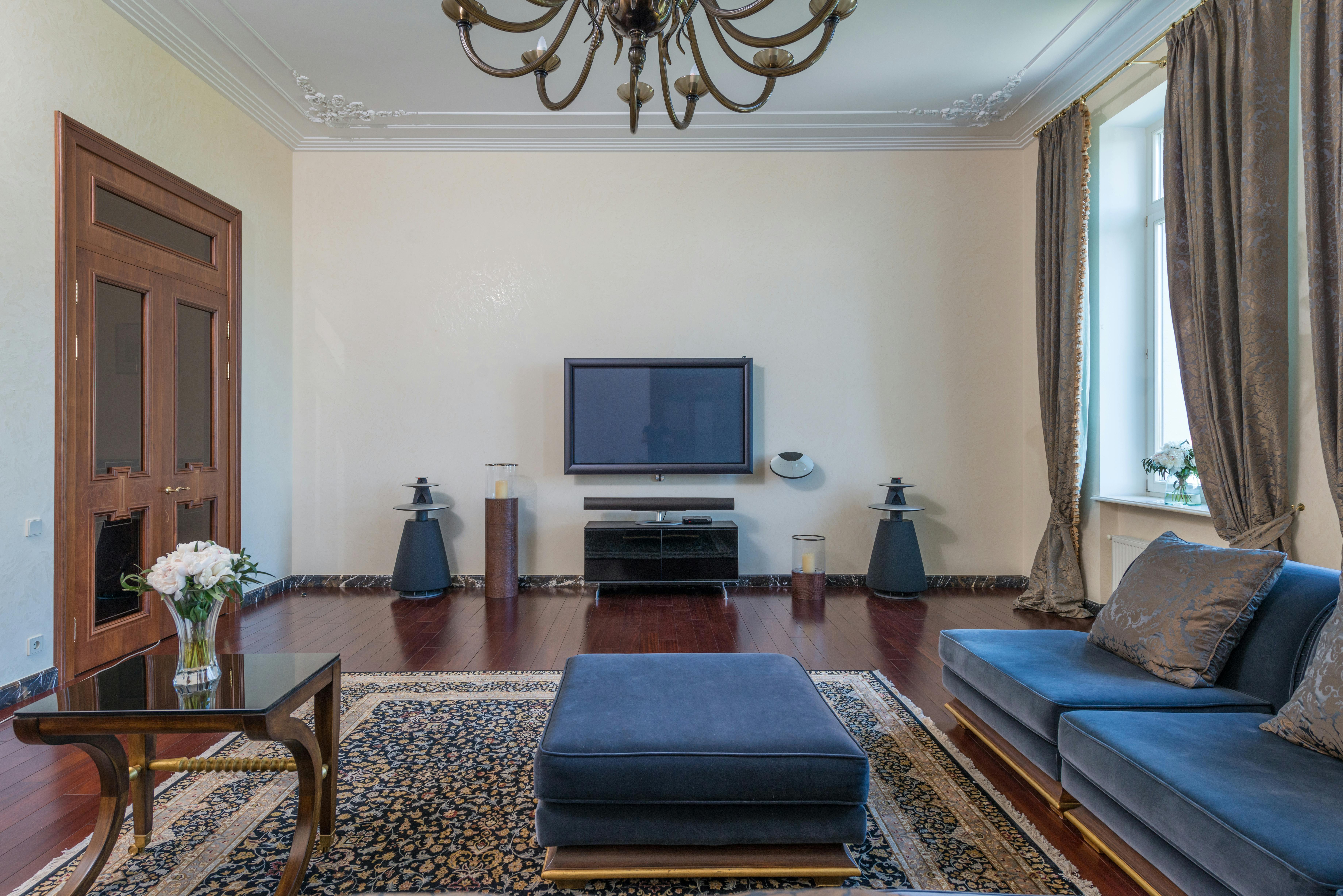 spacious living room with blue couch and table with flowers