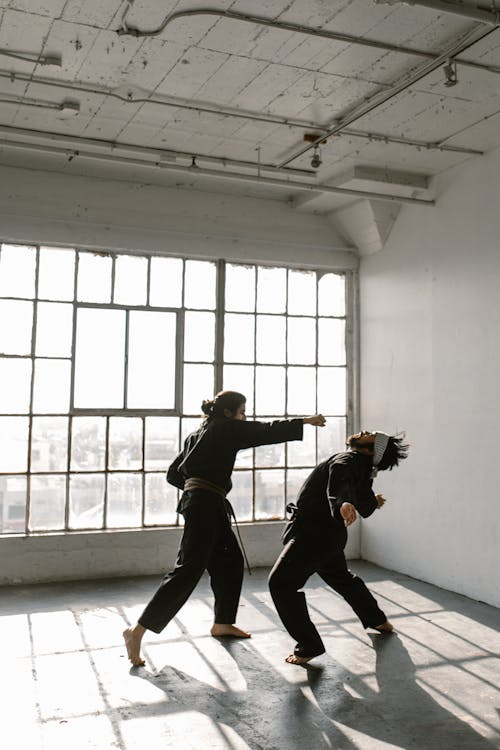 Free A Pair of Men in Black Dobok Showing a Self Defense Move Stock Photo
