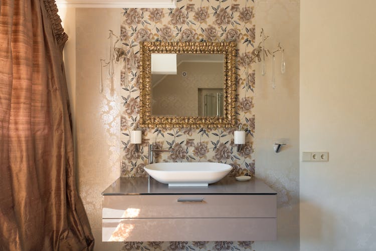 Square Shaped Mirror In Golden Frame Above White Sink