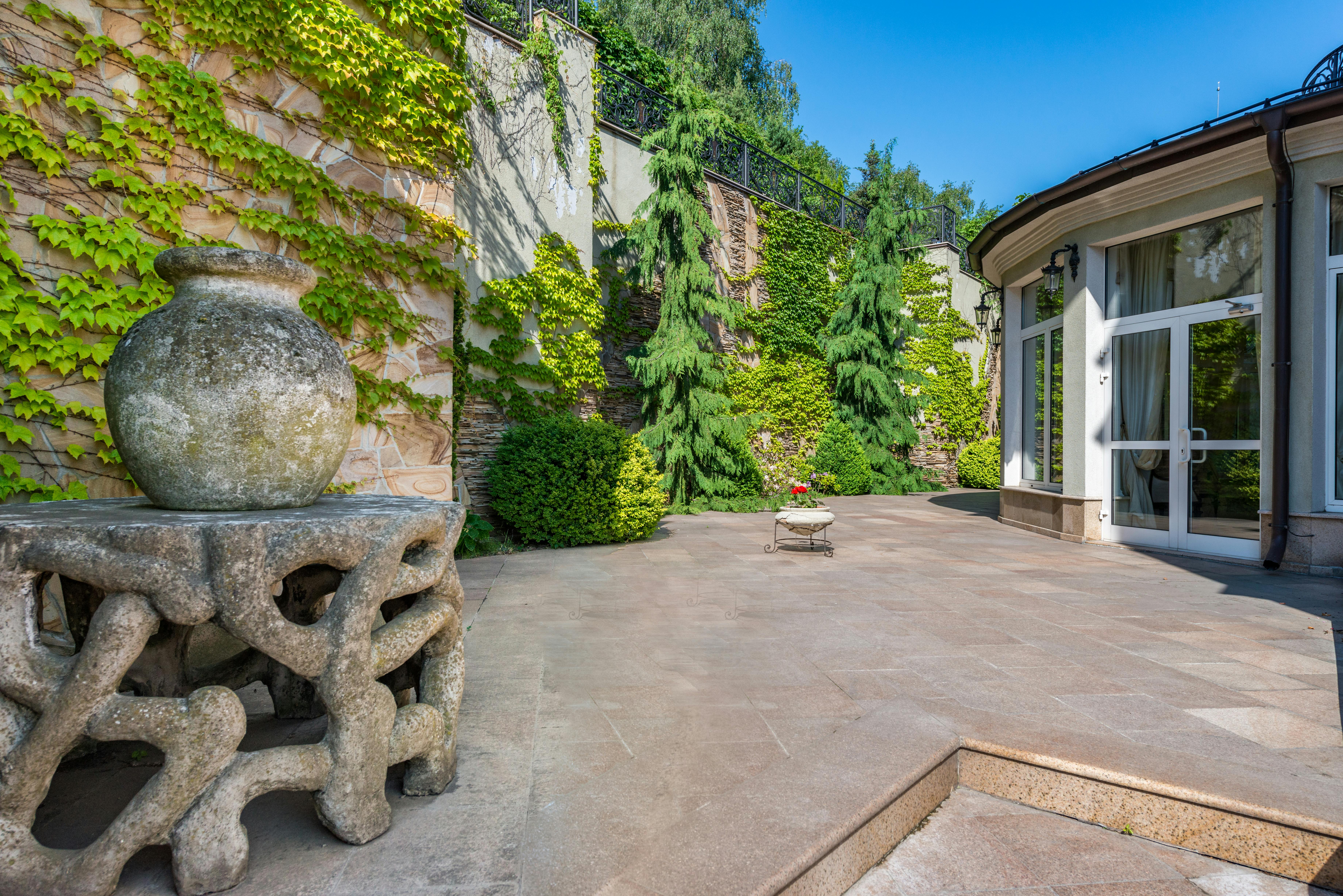 terrace with walls covered with green plants placed near house in daytime