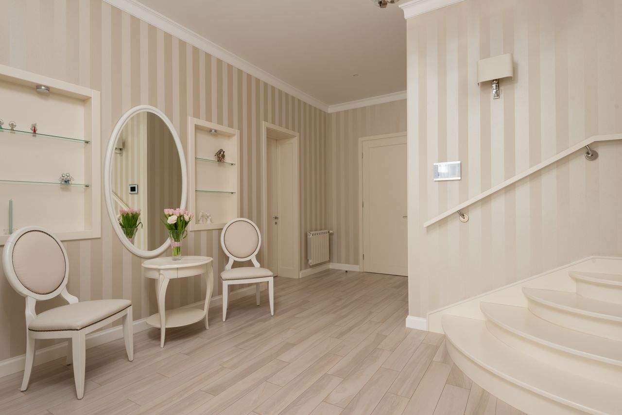 interior of spacious light entrance room with striped walls and stairs