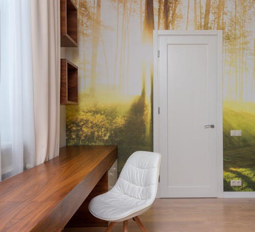 Contemporary interior of apartment with wall mural with sunny forest and timber long brown table