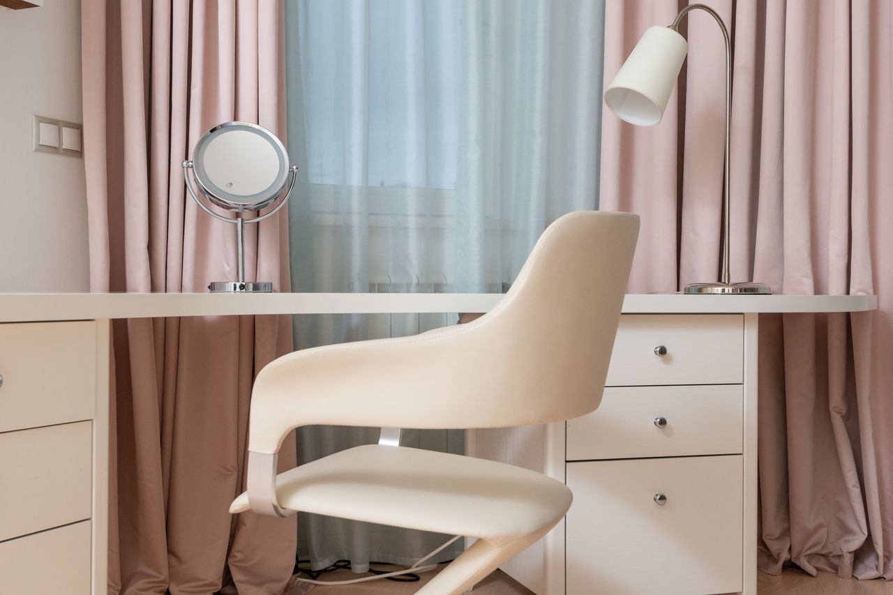 contemporary white chair near table with cabinet and lamp near window