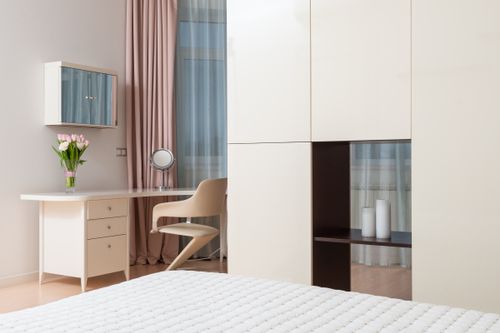 Free Interior of contemporary spacious apartment with white wardrobe and black shelf near bed Stock Photo