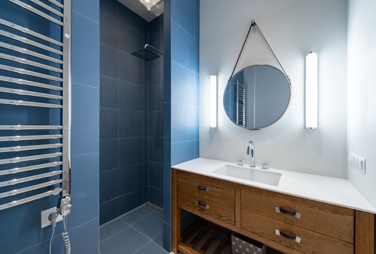 Bathroom With Shower And Round Mirror