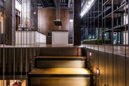Free Stairs leading to modern kitchen area and living room placed in luxury apartment Stock Photo
